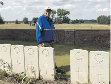  ??  ?? Paul Ferguson at the graveside of Pte. Roy Palmer at Woods Cemetery, near Ypres, Belgium.