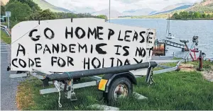  ??  ?? A sign painted on the side of a road in Lochaber, near Glencoe, earlier in lockdown