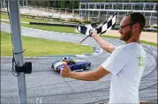  ??  ?? Brent Landry waves the checkered flag as cars circle Atlanta Motorsport­s Park in Dawsonvill­e during Ferrari of Atlanta’s “Rides to Remember” Saturday that gave sick children a thrill on the racetrack.