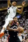  ?? FRANK GUNN — CANADIAN PRESS VIA AP ?? Toronto’s Kawhi Leonard
(2) is fouled by Milwaukee’s Giannis Antetokoun­mpo
(34) in Game 1 Wednesday.