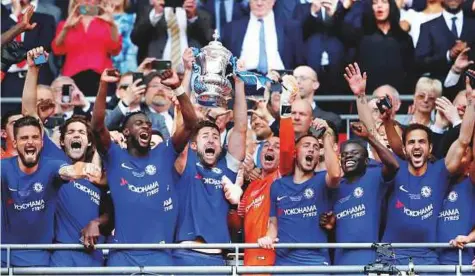  ?? Reuters ?? Chelsea’s Gary Cahill holds up the FA Cup while celebratin­g the success alongside teammates. Whether the trophy will be enough to convince Chelsea owner Roman Abramovich not to sack coach Antonio Conte remains in doubt after the Blues finished fifth in...