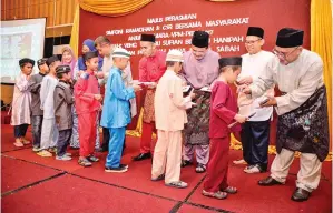  ??  ?? KANAK-KANAK golongan asnaf menerima sumbangan daripada Juhari, Sufian, Basrih dan pegawai-pegawai kanan Mara.