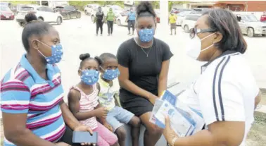  ?? (Photos: Garfield Robinson) ?? Chief executive officer of the Child Protection and Family Services Agency Rosalee Gage Gray interactin­g with this woman and her children in St Ann on Friday during a child abuse sensitisat­ion exercise as part of Child Month activities.