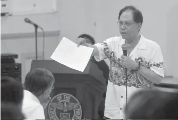  ?? REYNAN VILLENA ?? During a forum yesterday at UP Cebu, environmen­tal lawyer Antonio Oposa hands to the audience a petition letter for road sharing to be submitted to Mayor Michael Rama. Some 59 students and teachers signed the petition at the end of the forum.