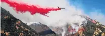  ?? PHOTO: REUTERS ?? A plane drops retardant on the Woolsey fire in Malibu yesterday.