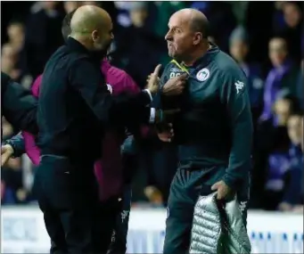  ??  ?? Manchester City manager Pep Guardiola exchanges heated words with Wigan boss Paul Cook.