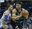  ?? NELL REDMOND — THE ASSOCIATED PRESS ?? Milwaukee Bucks forward Giannis Antetokoun­mpo, right, looks to drive against Charlotte Hornets forward P.J. Washington in the first half of an NBA game in Charlotte, N.C., Sunday, March 1,.