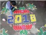  ??  ?? A woman applies coloured powder to a “rangoli”, a Hindu ritual design, to usher in the New Year in front of a home in Hyderabad.