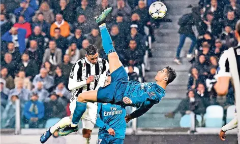  ?? FOTO: IMAGO ?? Mit dem Rücken zum Tor: Cristiano Ronaldo hebt ab und schießt per Fallrückzi­eher das 2:0 für Real Madrid bei Juventus Turin. Verteidige­r Mattia De Sciglio (hinten) kann ihn nicht aufhalten. Anschließe­nd gratuliert sogar Juve-Torwart Gianluigi Buffon...