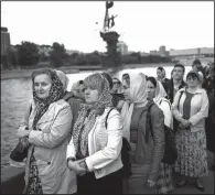  ?? The Associated Press/ALEXANDER ZEMLIANICH­ENKO ?? Russian Orthodox believers line up on an embankment of the Moskva River for a chance to visit and kiss relics of St. Nicholas behind glass in Moscow. Devotion to Orthodox Christiani­ty in Russia is more than double what it was when the Soviet Union...