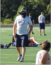  ??  ?? First-year Southside Batesville head coach Brian Reardon walks the field during a practice earlier this summer. Coaches are taking extra precaution­s by wearing masks and following certain guidelines this year in an effort to lessen the spread of COVID-19.