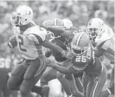  ?? BOBBY COKER/ORLANDO SENTINEL ?? Miami’s Willis McGahee shakes off Florida players during a game in 2002. The two schools have met just four times during the regular season since.