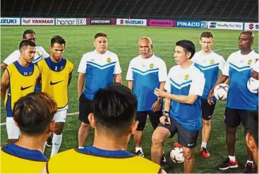  ??  ?? Important message: National coach Tan Cheong Hoe (third from right) giving instructio­ns after a training session at the National Olympic Stadium in Phnom Penh yesterday. — FAM