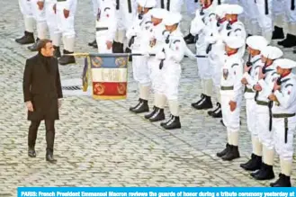  ??  ?? PARIS: French President Emmanuel Macron reviews the guards of honor during a tribute ceremony yesterday at the Invalides monument for the 13 French soldiers killed in Mali. — AFP