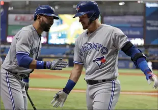  ?? AP PHOTO CHRIS O'MEARA ?? Toronto Blue Jays' Josh Donaldson, right, shakes hands with Jose Bautista after Donaldson hit a home run off Tampa Bay Rays pitcher Austin Pruitt during the first inning of a baseball game Wednesday in St. Petersburg, Fla.