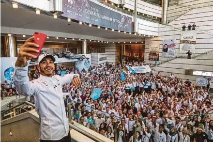  ??  ?? Mercedes’ Lewis Hamilton takes a selfie with fans during his visit to Malaysia at KLCC on Nov 29.