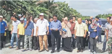  ??  ?? Julaihi (sixth left) flanked by Abdul Rahman on his right and Siti walking on a stretch of the 3 km road which is being resurfaced at a cost of RM2.5 million. The road project is under Malaysian Road Records Informatio­n System (Marris).