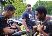  ??  ?? Vaun Mayes (center) watches as Timothy Montgomery runs drills with Laurenz Hardin, 10, during a martial arts class at Sherman Park. Mayes started Program The Parks before the unrest last summer. “I don’t think a lot of the root issues for why the riots...