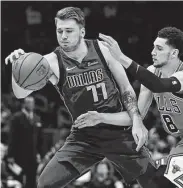  ?? Jonathan Daniel / Getty Images ?? The Mavericks’ Luka Doncic, left, tries to gain control while being harassed by the Bulls’ Zach LaVine.