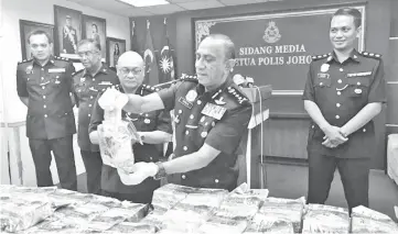  ??  ?? Khalil Kader showing one of the seized drug packaging containing syabu (crystal methamphet­amine).