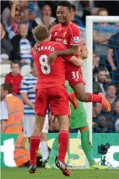  ?? — AP ?? Liverpool’s Raheem Sterling ( right) and Steven Gerrard celebrate after QPR’s Steven Caulker scored an own goal in stoppage time during their EPL match at Loftus Road in London on Sunday. The Reds won 3- 2.