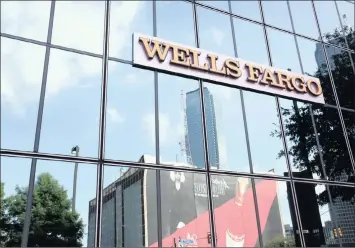  ??  ?? Wells Fargo signage displayed on the exterior of a bank branch in Dallas, Texas. Wells Fargo is coming under a lot of pressure for security breaches.