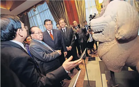  ??  ?? COOPERATIO­N: Cambodian Foreign Minister Hor Namhong and Thai counterpar­t Tanasak Patimaprag­orn inspect one of the artefacts returned yesterday.