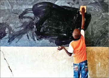  ?? MICHELE CATTANI/AFP ?? A young boy cleans the blackboard on the first day of school in Segou, Mali on Tuesday – several volunteer families in Segou provide assistance and rooms to people displaced from nearby areas threatened by jihadists.