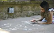  ??  ?? Saorise Welsh Dwyer, 10 of Vacaville draws a “Black Lives Matter” message in chalk art as she listens to speakers during a vigil for Daunte Wright Sunday in Creekwalk Plaza.