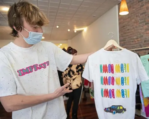  ?? Emily Matthews/Post-Gazette photos ?? Adam Klenovich, 17, a junior at Beaver Area High School, holds the first shirt he made — in May 2020 — at Gallery 4413 in Lawrencevi­lle. His and his friends’ work will be on display at the gallery on Butler Street all month.