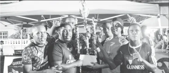  ??  ?? Devon Charles of Sparta Boss alongside his joyous team-mates, collecting the coveted championsh­ip trophy and prize monies from Three Peat Promotions Rawle Welch (2nd from right), following their 3-1 victory over Uprising in the finale of the Guinness ‘Cage’ Streetball Championsh­ip at the Haslington Market Tarmac