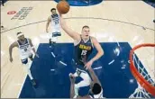  ?? Abbie Parr Associated Press ?? DENVER’S Nikola Jokic takes a shot over Minnesota’s Anthony Edwards in the Nuggets’ Game 4 win.