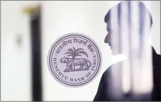  ?? (AP) ?? A man walk past a Reserve Bank of India logo at their head office in Mumbai, India, on Feb 7. India’s central bank has lowered its key interest rate by a quarter of a percentage point to 6.25 percent, a step that is expected to boostthe economy.