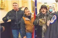  ?? MANUEL BALCE CENETA/ASSOCIATED PRESS ?? Michael Sparks, left, and Kevin Seefried, second from left, as they and other insurrecti­onists loyal to President Donald Trump are confronted by U.S. Capitol Police officers outside the Senate Chamber inside the Capitol in Washington, Jan. 6, 2021.