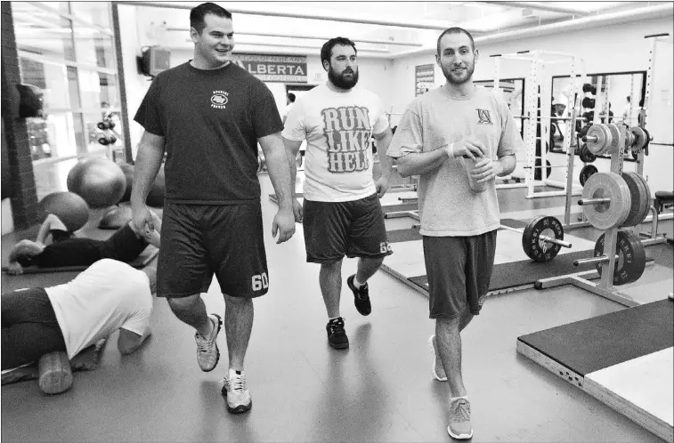  ?? Jason Franson,the journal ?? Former University of Alberta football players Dale Stevenson, left, Gord Hinse and Hugh O’neill walk through the gym at the U of A south campus on Friday.