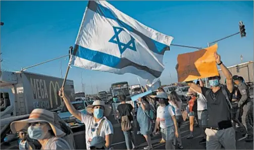  ?? SEBASTIAN SCHEINER/AP ?? Social workers protest the country’s economic situation in Kfar Ahim, Israel, as coronaviru­s surges out of control.