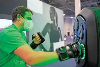  ?? ?? An attendee uses a Liteboxer interactiv­e boxing home workout during the CES tech show in Las Vegas, Nevada. Interactiv­e comment sections and virtual reality headsets: internet-connected fitness gear and services have boomed during the pandemic as at-home athletes seek a proxy for gym life.