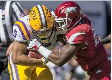  ?? NWA Democrat-Gazette/BEN GOFF ?? Arkansas linebacker Dre Greenlaw tackles LSU running back Derrius Guice in a Nov. 11 game at Tiger Stadium in Baton Rouge. After nearly seven years of calling Greenlaw their son, Brian and Nanci Early officially adopted him in July, shortly after he turned 21.