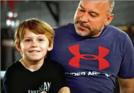  ?? COURTESY OF MIKE HASKEY ?? Nine-year-old Landon Paris (left) is involved in a youth wrestling program in Columbus. His dad, Carson (right), and grandfathe­r were high school wrestlers.