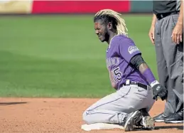  ?? Sue Ogrocki, The Associated Press ?? Colorado’s Raimel Tapia grimaces after being hit by a thrown ball while stealing second base in the sixth inning of a spring training baseball game against the Kansas City Royals on Sunday in Surprise, Ariz.
