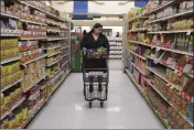  ?? ALLISON DINNER — THE ASSOCIATED PRESS ?? Jaqueline Benitez pushes her cart down an aisle as she shops for groceries at a supermarke­t in Bellflower on Feb. 13. Benitez, 21, who works as a preschool teacher, depends on California's SNAP benefits to help pay for food.