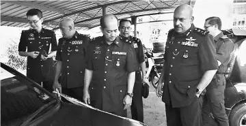  ??  ?? (From front right) Dev Kumar and Miri deputy police chief Supt Stanley Jonathan Ringgit inspect the suspect’s car.