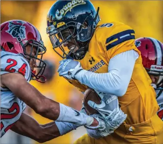  ?? Kevin Karzin/For The Signal ?? College of the Canyons Damaris August (5) hangs on to the ball as Santa Barbara City College’s Javan Gail (24) tries to knock it loose after a 10-yard reception during the second quarter.