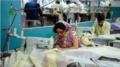  ?? — AFP ?? Employees work in a textile factory in Karachi. The interest rate cut in Pakistan can help export-oriented industrial sectors as they need commercial bank loans and cash from other sources at reasonable rates.