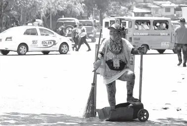  ?? BING GONZALES ?? A STREET sweeper rests under the shade while cleaning his assigned area along Roxas Avenue.