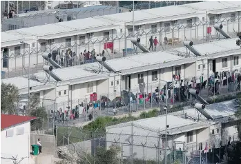  ?? PETROS GIANNAKOUR­IS/THE ASSOCIATED PRESS ?? More than 3,000 migrants are staying at the Moria camp on the Greek island of Lesbos and are to be sent back to Turkey because European officials have cut off the flow of new asylum seekers.