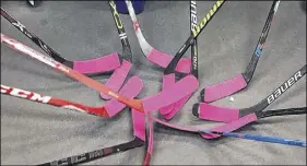  ??  ?? Hockey sticks are taped with pink tape in support of the Pink Tape Campaign.