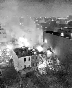  ?? — Reuters photo ?? Firefighte­rs are seen on a roof as flames engulf an apartment building in Brooklyn, New York, US obtained from social media.