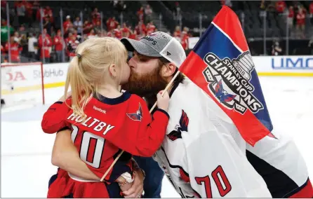  ??  ?? TheAssocia­tedPress
Washington Capitals goaltender Braden Holtby, right, kisses his daughter Belle after the Capitals defeated the Vegas Golden Knights 4-3 in Game 5 of the Stanley Cup final in Las Vegas on June 7, 2018.