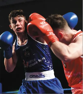  ??  ?? Holy Family’s Eugene McKeever, left, takes a blow from Kieran Molloy during their final at the Liffey Crane Hire IABA Elite Boxing Championsh­ips in the National Stadium.